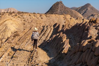 A young hiker girl walking the landscapes of Colas de Dragon in the desert of Tabernas