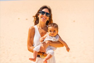 Young mother with her son in the dunes of the Corralejo Natural Park