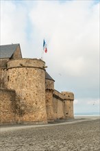 Walls of the famous Mont Saint-Michel Abbey at low tide in the Manche department
