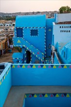 Stairs of colors that go up to a beautiful terrace of a traditional blue house in a Nubian village next to the Nile river and near the city of Aswan. Egypt