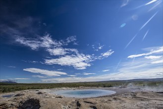 Geysir Strokkur with the sun in the background of the golden circle of the south of Iceland