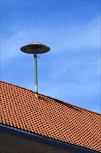 Old siren on red tiled roof in Allgaeu