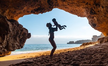 Mother with son in the cave on the beach in the Algarve