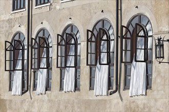 Window front with white curtains in historical building