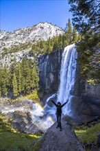 A woman in Long Vernal Falls waterfall in Yosemite National Park. California