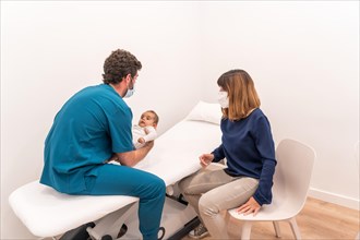 Horizontal photo with copy space of a pediatrician examines baby during well check appointment