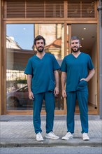 Vertical portrait of two doctor in uniform in the entrance of a clinic