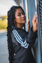 Urban session. Young black ethnic woman with long braids and with tattoos
