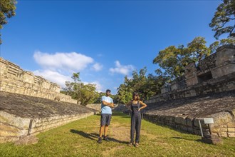A couple strolling through the ball game in the temples of Copan Ruinas. Honduras
