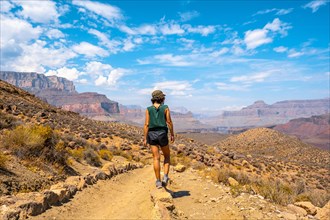 A young woman with green shirt resting on the South Kaibab Trailhead trekking. Grand Canyon