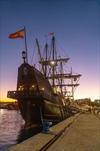 Old boat at sunset on the promenade of Muelle Uno in the Malagaport of the city of Malaga