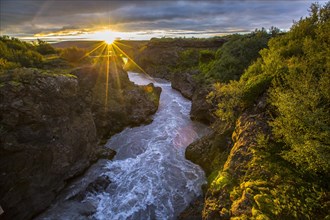 Gorgeous sunset on the wooden bridge of the Barnafoss river