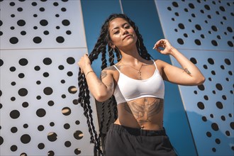 Young woman of black ethnicity with long braids and tattoos