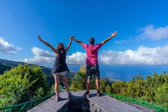 A very happy couple on top of the mountain at the viewpoint of the Cubo de la Galga natural park on the northeast coast on the island of La Palma