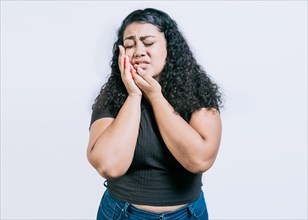 Young woman suffering with toothache isolated. Girl rubbing cheek with toothache on white background