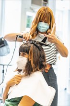 Hairdresser with mask and client