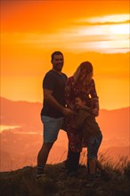 Parents with their son on top of a mountain at sunset. Adventure lifestyle A summer afternoon in the mountains of the Basque country