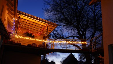 Terrace with festive lighting with walnut tree in the background