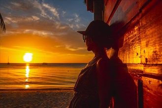 A young woman with a cap at Sunset on West End Beach
