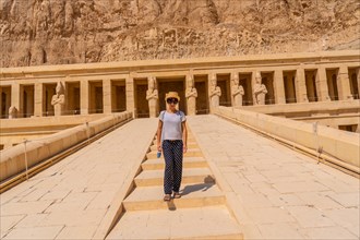 A young woman on the entrance stairs to the Funerary Temple of Hatshepsut in Luxor. Egypt