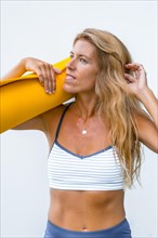 Fitness and yoga session with a young blonde Caucasian woman dressed in a casual outfit. On a white background