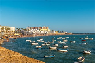 La Caleta beach full of tourism in the summer sunset of the city of Cadiz. Andalusia