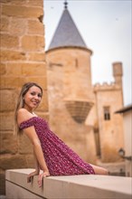 Portrait of a blonde woman smiling next to a medieval castle