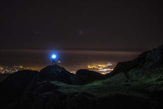 Silhouette of a young man with a blue light on Mount Aiako Harria in Oiartzun. Basque Country
