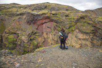 A young woman on a cliff in the Landmannalaugar valley on the trek. Iceland