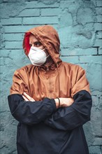 A young man with mask and hood. First walks of the uncontrolled Covid-19 pandemic