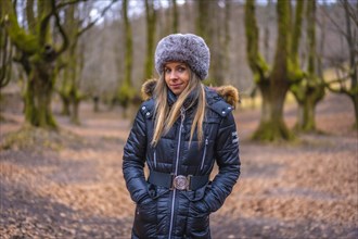 Blonde girl with Russian hat in a beautiful forest