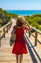 A young girl on the wooden path to Playa Moncayo in Guardamar del Segura next to Torrevieja