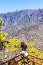 A young tourist at the Mirador Lomo de las Chozas de La Cumbrecita on the island of La Palma next to the Caldera de Taburiente