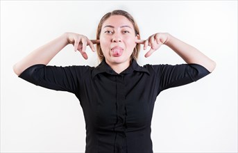 Displeased girl covering ears and sticking out tongue isolated. Young woman covering her ears and making faces isolated