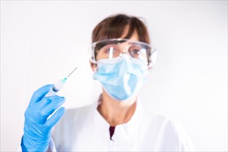 Female doctor with transparent glasses face mask with coronavirus vaccine