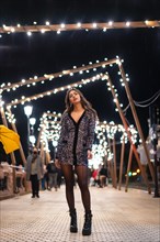 Christmas lifestyle. Caucasian brunette in a fashionable sequined dress and black shoes with heels