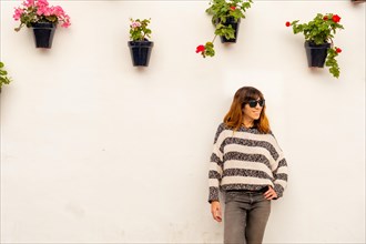 Portrait of a young tourist in the pots with flowers in the white houses of the town of Nerja
