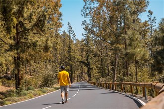 A young man walking along the forest road on the way up to Teide Natural Park in Tenerife