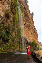 A mother with her son at the waterfall that falls on the road called Anjos Waterfall