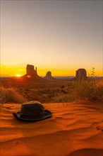 A green hat on the red sand at dawn in Monument Valley
