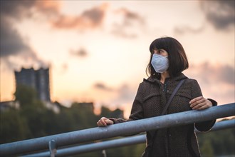 A young brunette with a mask on a sunset enjoying the first walks. First walks of the uncontrolled Covid-19 pandemic
