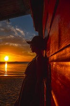 A young woman with a cap at West End Sunset in the Caribbean Sea