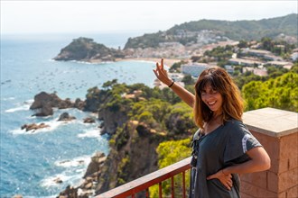 A young tourist looking at Tossa de Mar from the viewpoint in the summer