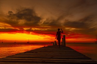 A young woman walking in the sunset on West End beach in Roatan