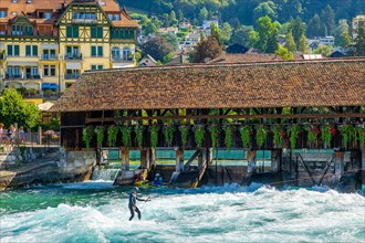 Beautiful Obere Schleuse Bridge in City of Thun and a Surfer in a Sunny Summer Day in Bernese Oberland
