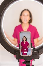 Vertical photo of a nutritionist woman filming video with the mobile phone