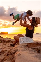 Mother with her son at sunset in Cala Comte beach on the island of Ibiza. Balearic