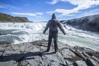 A young man above the Gullfoss waterfall in the golden circle of the south of Iceland