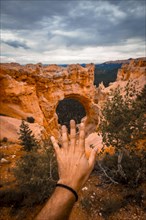 Extended hand in The Arch Grand Escalante in Bryce National Park. Utah