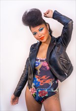 A closeup portrait of a fashion attractive rocker style woman with bright makeup wearing a leather jacket
